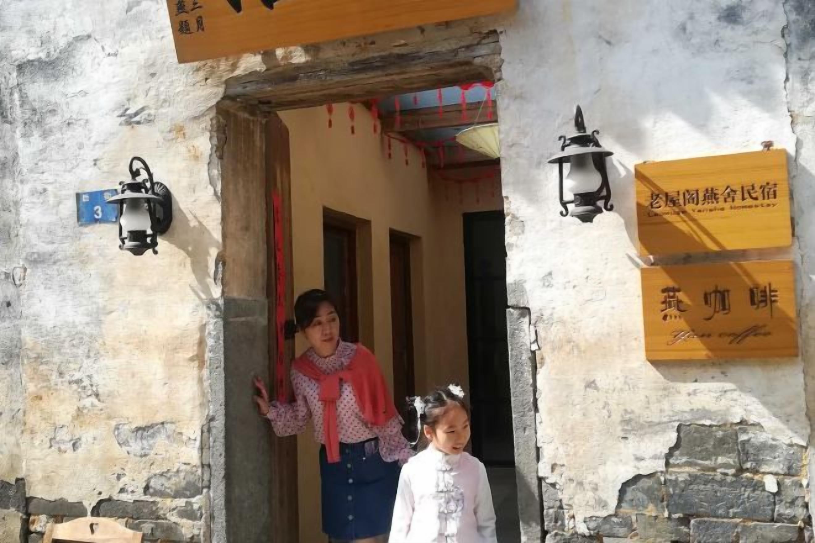 A doorway with a sign indicating a room number and a lamp.