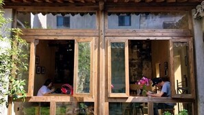 Un edificio tradicional de madera con ventanas grandes y techo de tejas.
