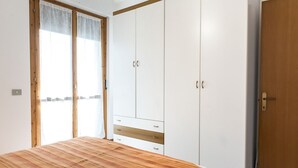 Makuuhuone, jossa on sänky, vaatekaappi ja ovi.
