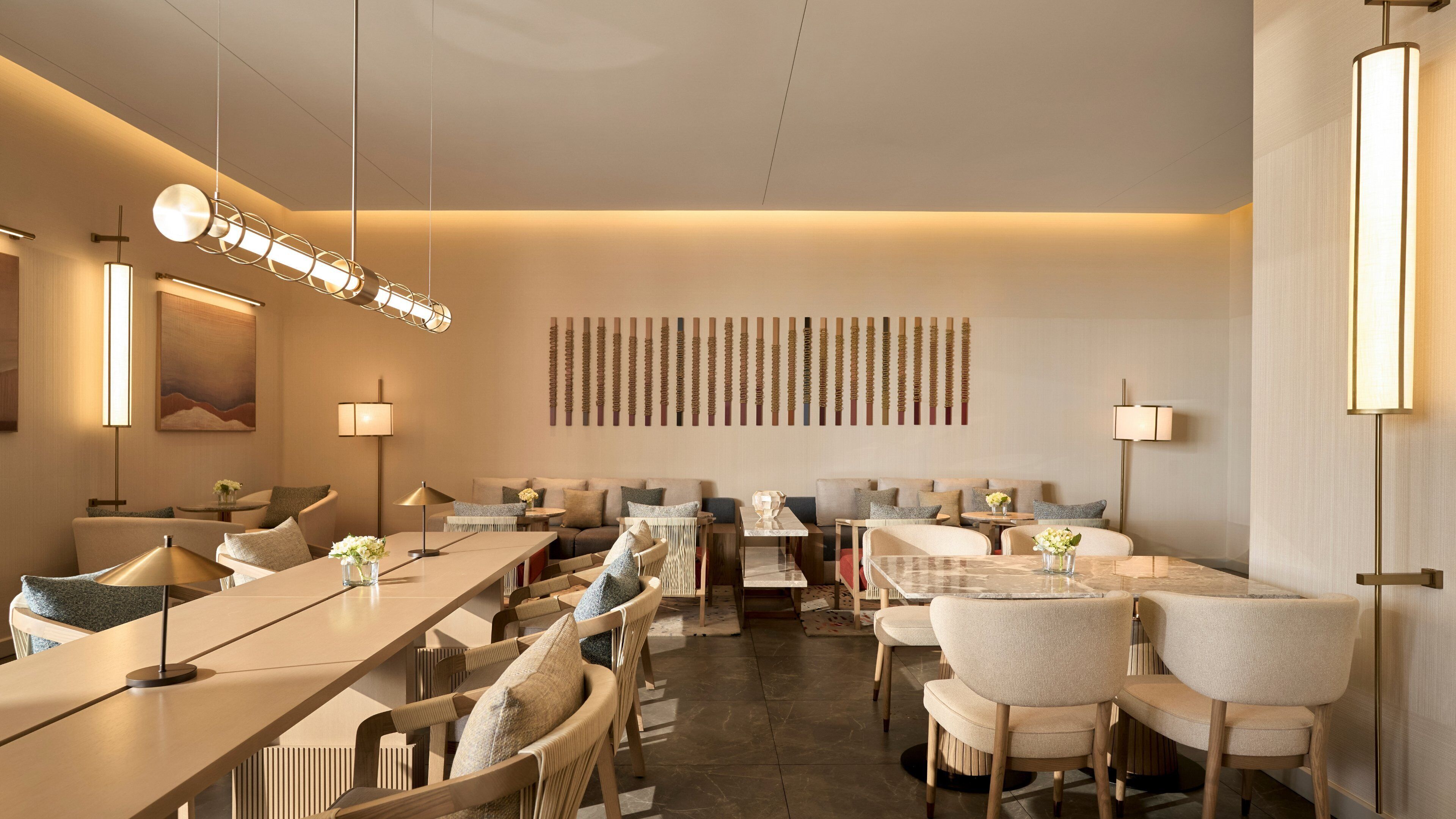 A modern hotel lobby with a long reception desk, comfortable seating areas, and contemporary lighting fixtures.