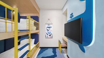 Dormitorio con tres literas, un televisor de pantalla plana y un cartel de ballenas.