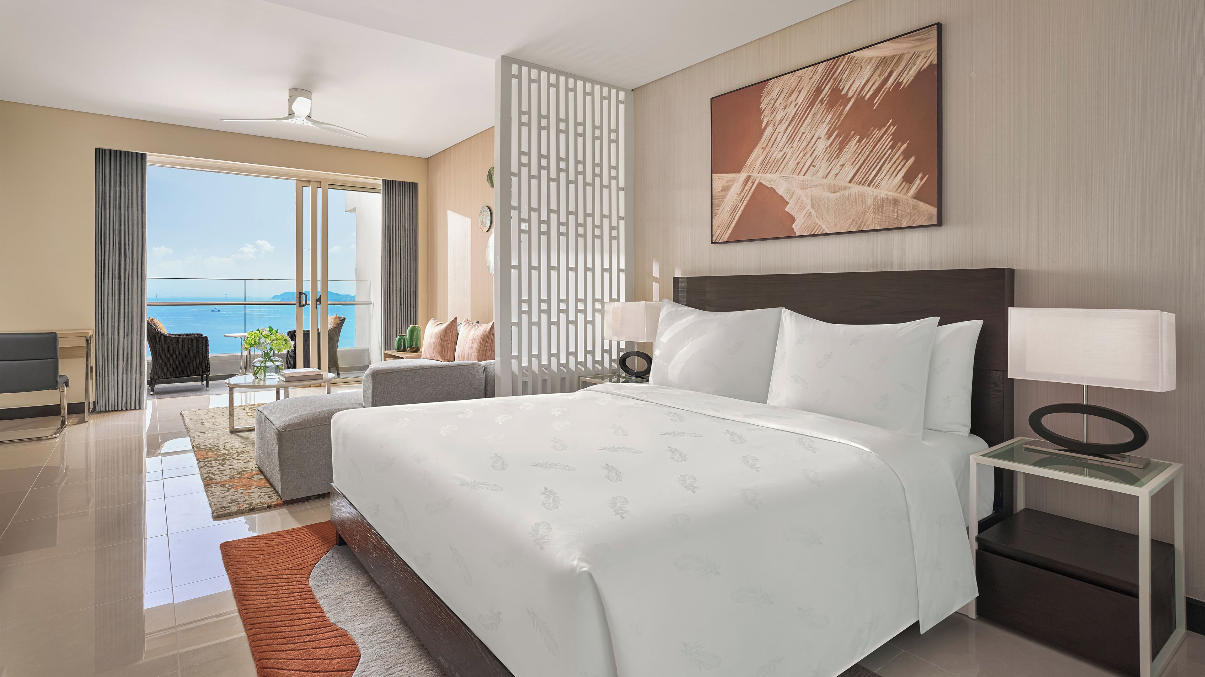 Une chambre d’hôtel moderne avec un grand lit, une vue sur la mer et un balcon.