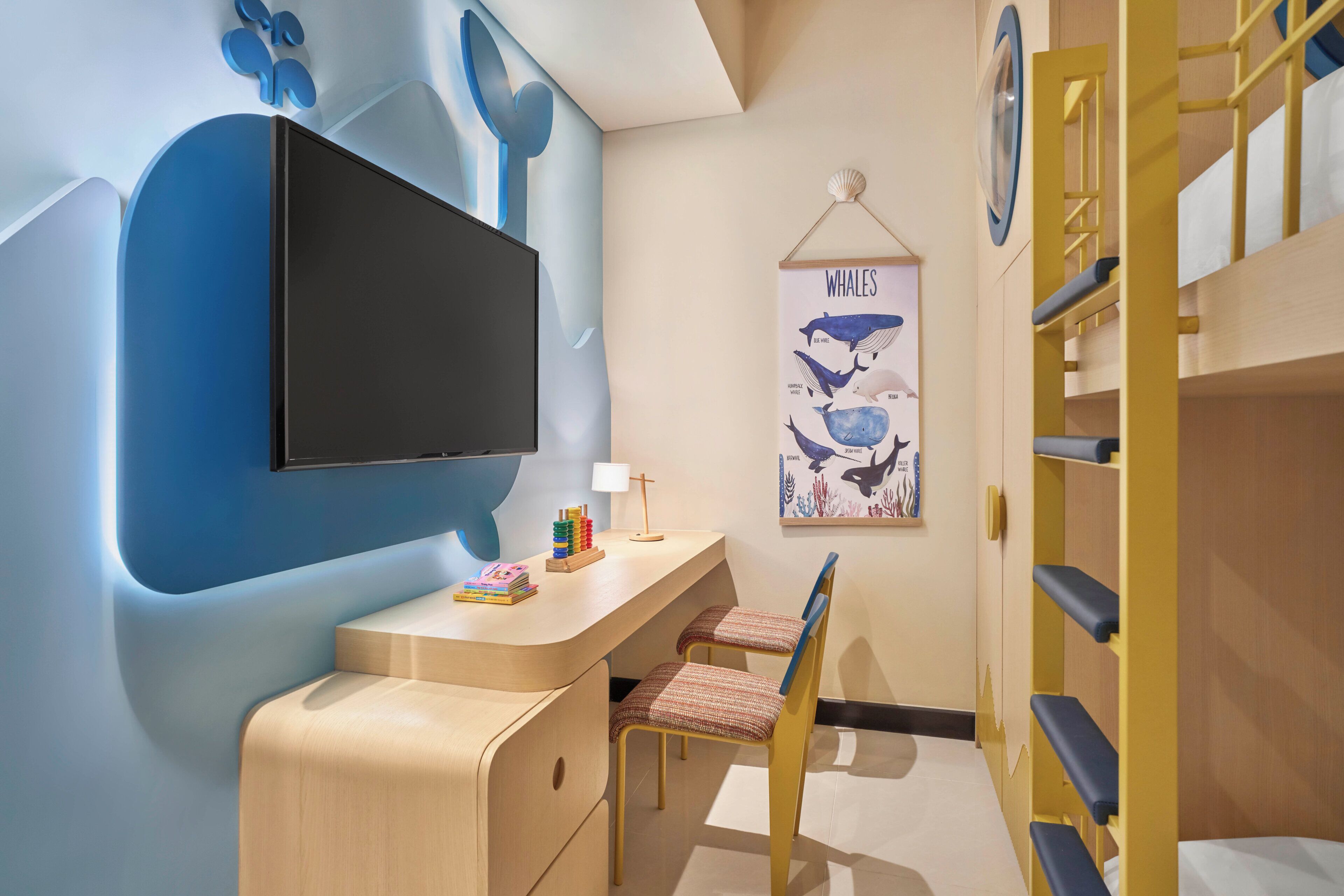 A child's room with a desk, chair, bunk beds, and a whale poster.