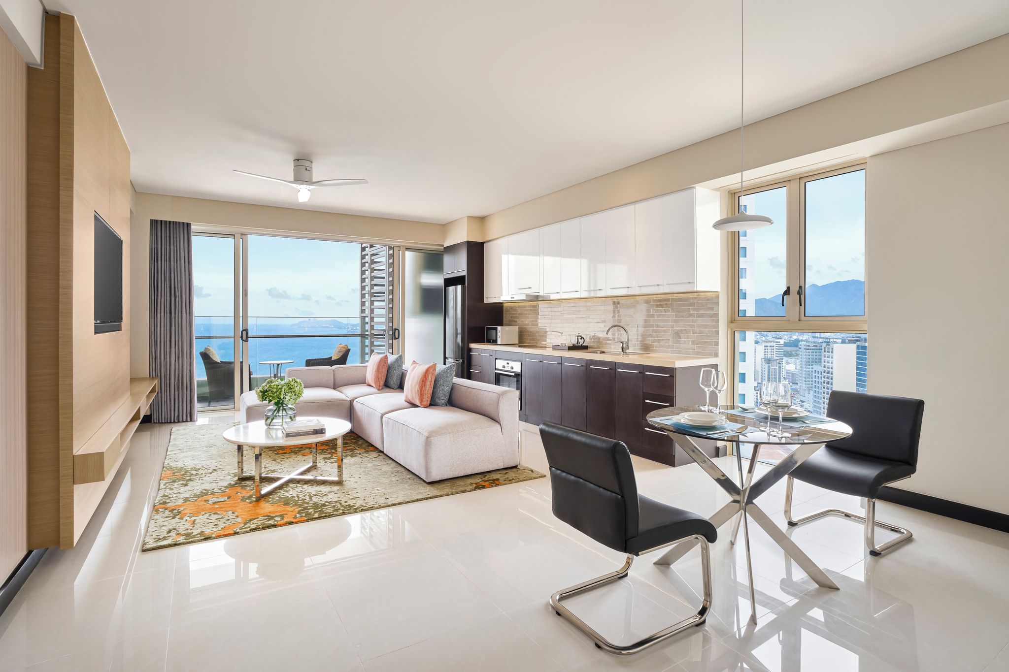 A modern apartment with a living room, dining area, and kitchen, featuring a large window with a city view.