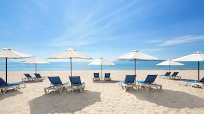 Nära stranden, solstolar, parasoller och strandhanddukar