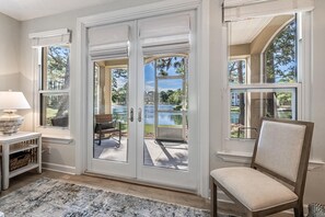 Enjoy the serene view from your patio, overlooking the water, with a wicker chair and table at your disposal.