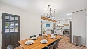 Una cocina moderna con gabinetes blancos, un refrigerador de acero inoxidable y un horno empotrado.