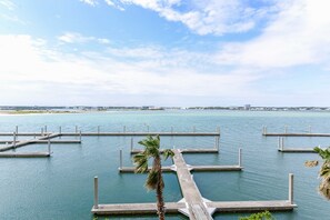 Un puerto deportivo con varias muelles que se adentran en aguas tranquilas, rodeado por un cielo despejado.