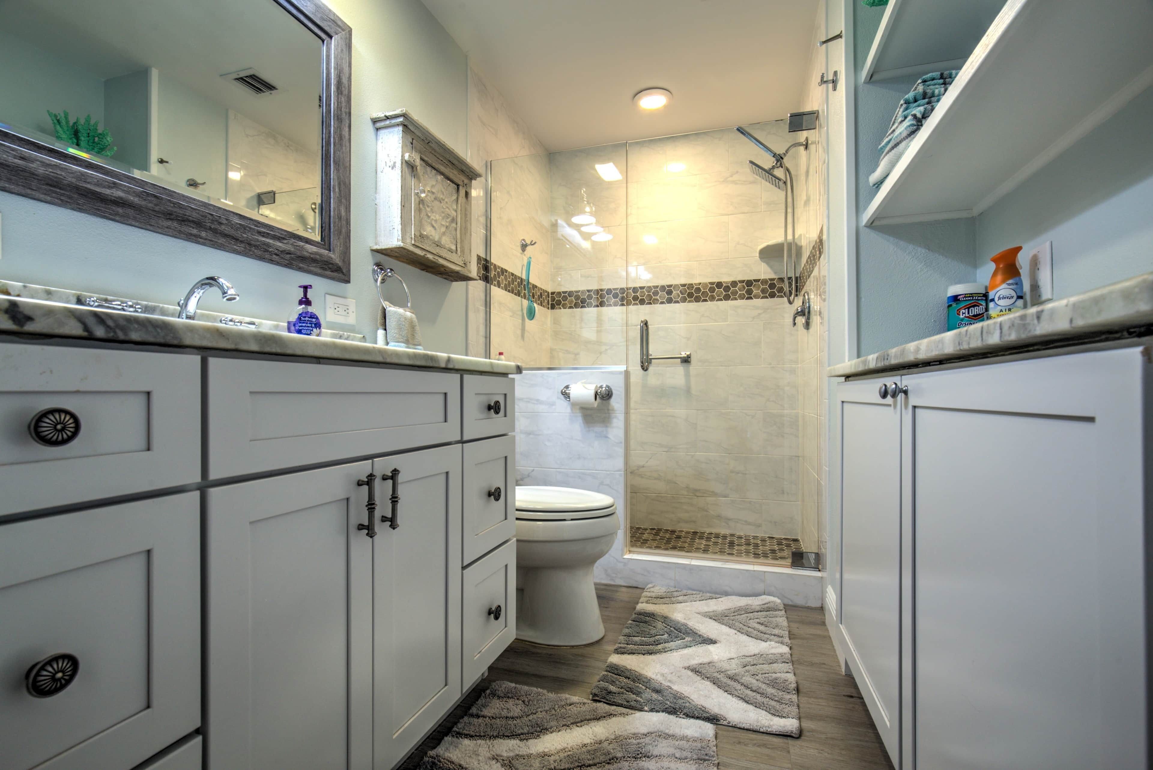 A modern bathroom with a shower, toilet, and vanity.