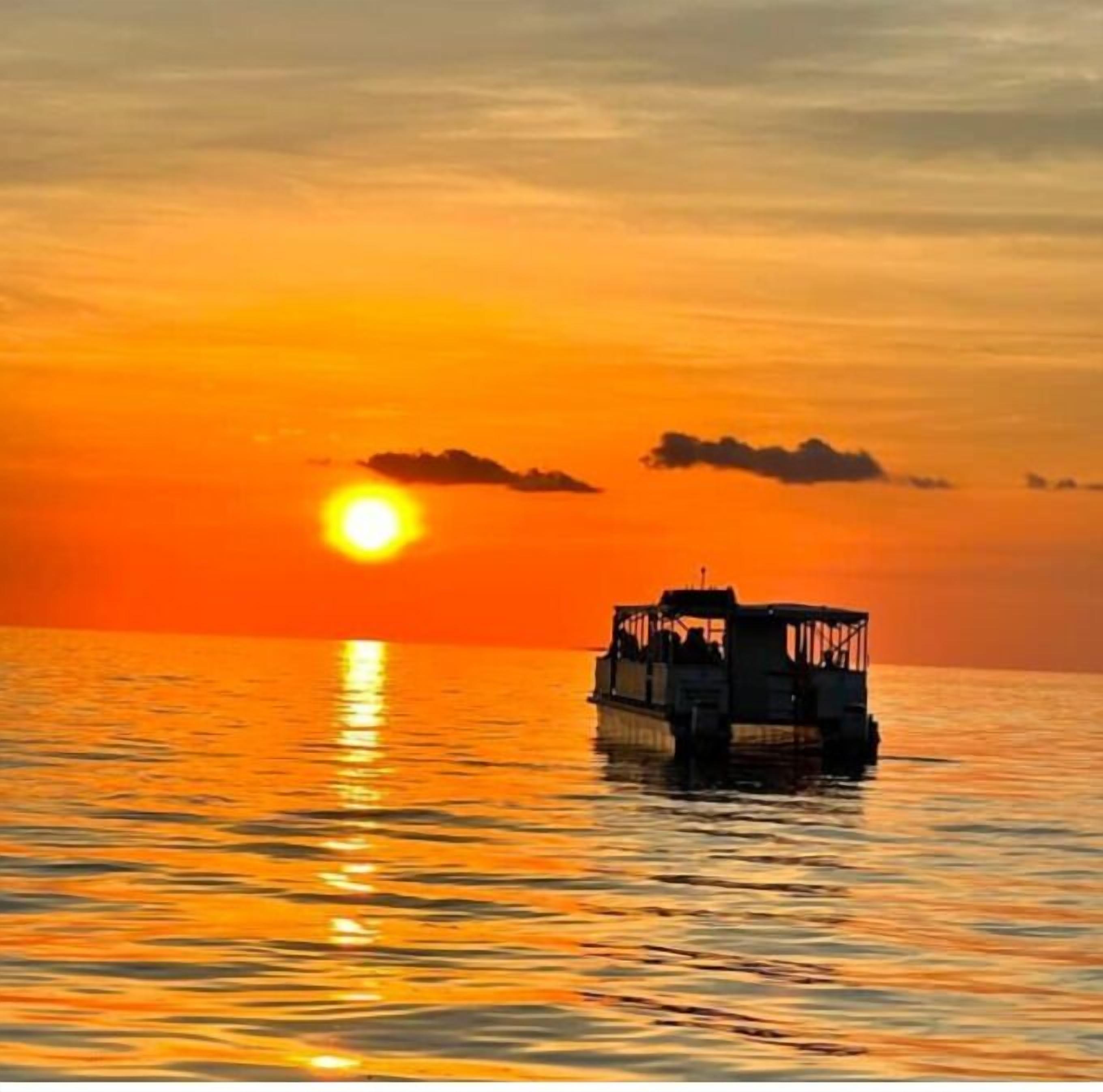 A boat on calm water during sunset.
