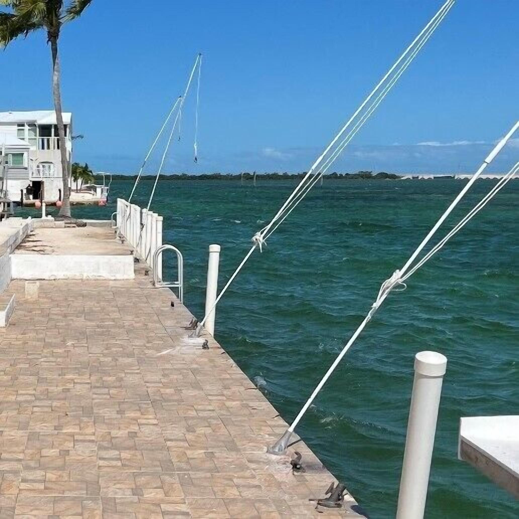 A paved walkway by the sea with a building in the background.