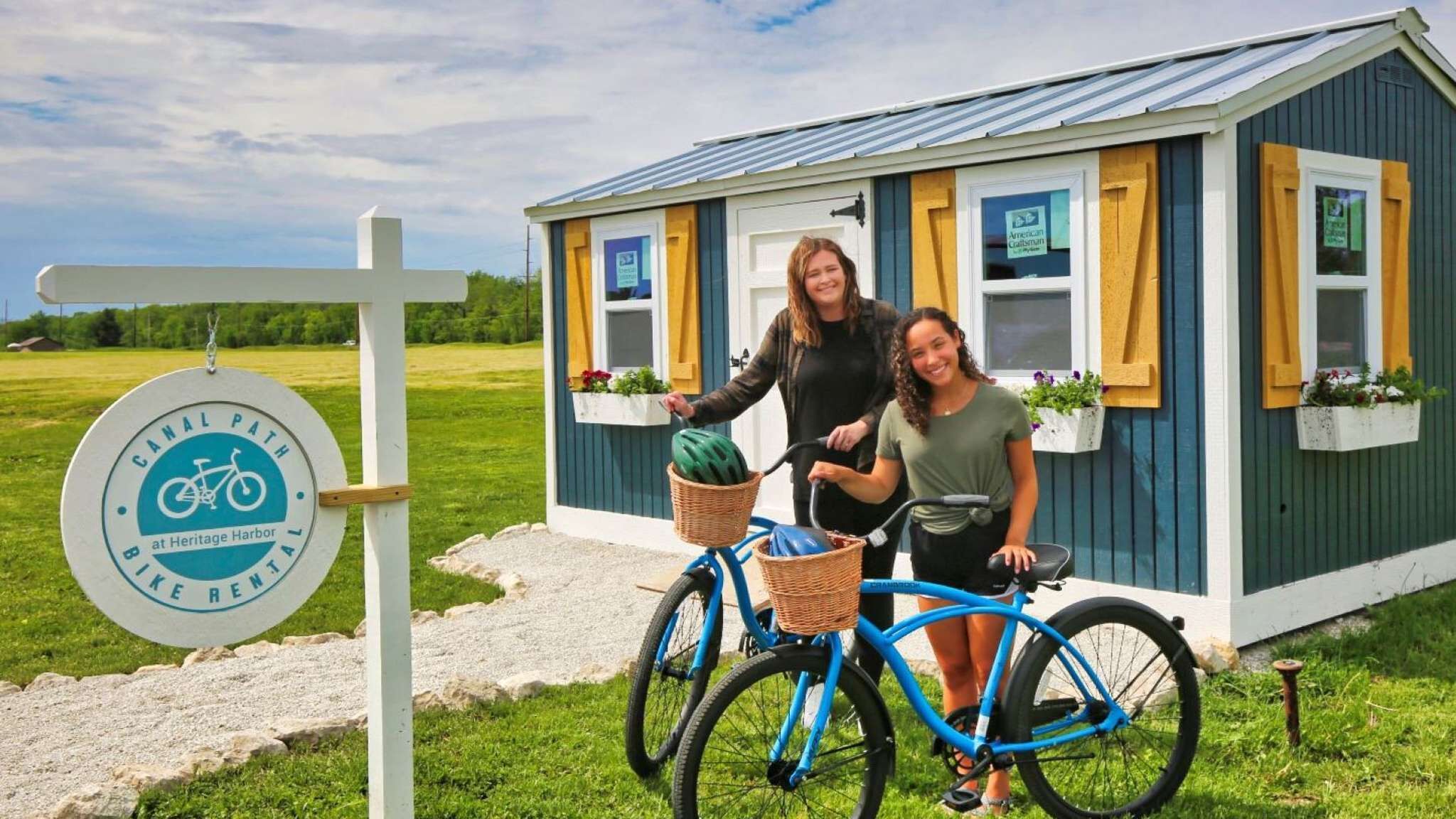 A small blue building with a sign indicating a canal path at Heritage Harbor.