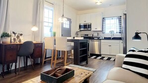 Un espacio habitable compacto con kitchenette, comedor y zona de estar.