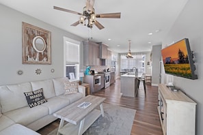A modern living room with a sofa, coffee table, and a ceiling fan.