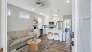 A modern kitchen with white cabinets, stainless steel appliances, and a central island with bar stools.
