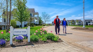 A residential street with a sign reading 'Harbor Walk,' houses, and a pedestrian walkway. - The Bunkies @ Heritage Harbor (Ottawa)