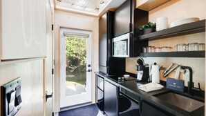 A compact kitchen with a coffee machine, a sink, and a small countertop. - The Bunkies @ Heritage Harbor (Ottawa)