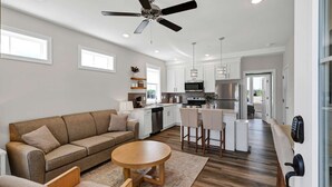 A modern kitchen with white cabinets, a stainless steel refrigerator, and a built-in oven. - Dog Friendly Condo | Navvy Town Neighborhood (Ottawa)