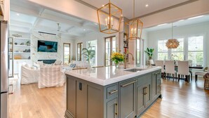A spacious kitchen with a large island, pendant lighting, and a view of the dining area. - Brand New Luxury 6 bedrooms, 7.5 bathrooms, pool, spa, elevator, ocean views (Isle Of Palms)