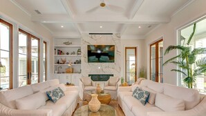 A spacious living room with two sofas facing a central coffee table, a television mounted on the wall, and a fireplace. - Brand New Luxury 6 bedrooms, 7.5 bathrooms, pool, spa, elevator, ocean views (Isle Of Palms)