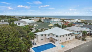 Un quartier résidentiel avec des maisons, une piscine et une vue sur l’océan.