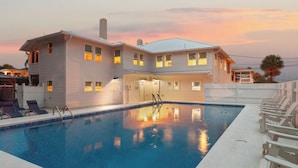 Ein zweigeschossiges Haus mit Schwimmbad, überdachter Terrasse und umzäunter Garten.