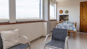 A dining area with a table set for four, a window with a view, and a door to the right.