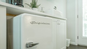 Un réfrigérateur blanc avec une poignée chromée et le mot « Frigidaire » inscrit sur la porte.
