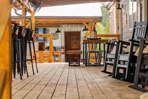 A wooden deck with outdoor seating and a wooden building in the background.