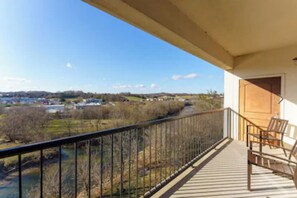 Enjoy the serene river views from this balcony, featuring a comfortable seating area with two chairs.