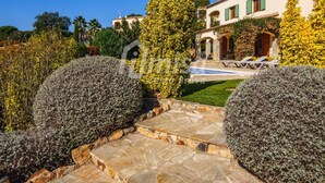 A Mediterranean-style villa with a swimming pool, stone pathway, and lush garden. - Villa Isabela, Calonge - Costa Brava (Calonge)