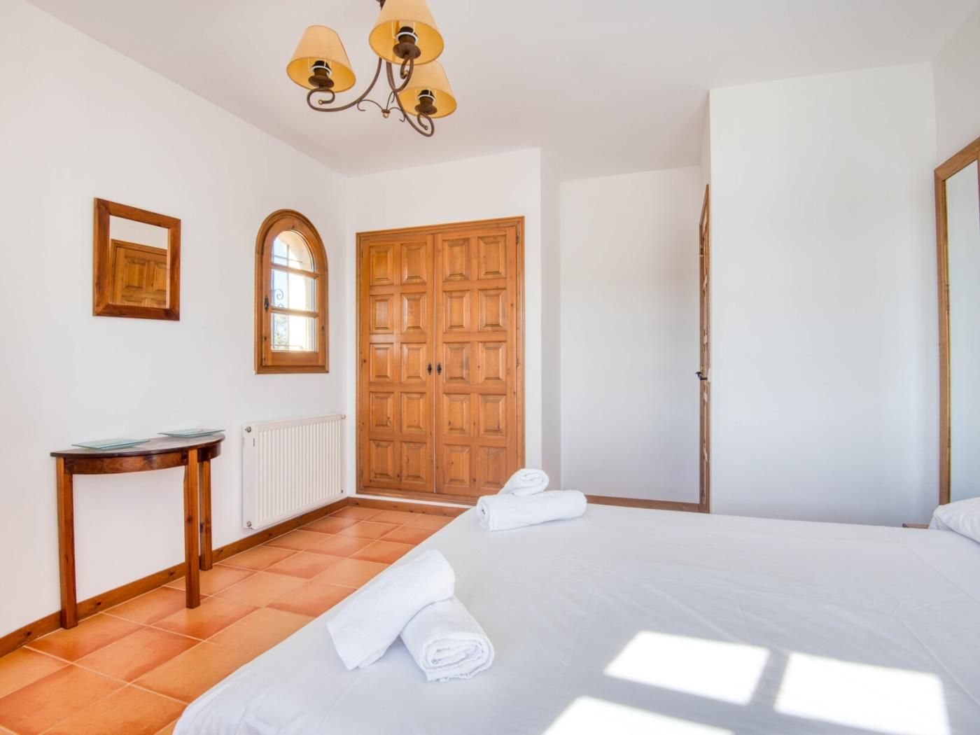 Ein Hotelzimmer mit einem Bett, einem Holzschrank, einem kleinen Tisch und einem Fenster.