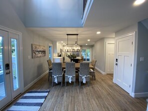 A dining area with a central island, a chandelier, and a view of the outdoors. - Bayfront, Sleeps 10, Boat Slip, 3 BR/2.5 BATH, Main Pool Open After Labor Day (Ocean City)