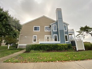 A two-story house with a prominent chimney, a front porch, and a well-maintained lawn. - Bayfront, Sleeps 10, Boat Slip, 3 BR/2.5 BATH, Main Pool Open After Labor Day (Ocean City)