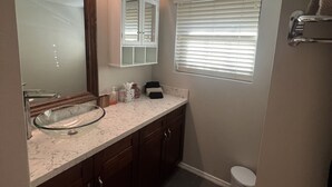 A bathroom with a glass bowl sink, wooden cabinets, a mirror, and a window with blinds. - Scottsdale Couples Getaway| Pool & Hot Tub| Scenic (Scottsdale)