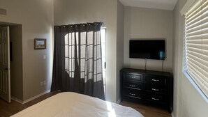 A bedroom with a bed, a ceiling fan, a TV, a dresser, and a window with blinds. - Scottsdale Couples Getaway| Pool & Hot Tub| Scenic (Scottsdale)