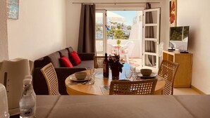 Un salon confortable avec un canapé, une table à manger, des chaises et un téléviseur.