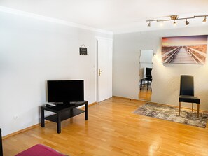 Relax in this stylish living room with a flat-screen TV, framed artwork, and comfortable seating.