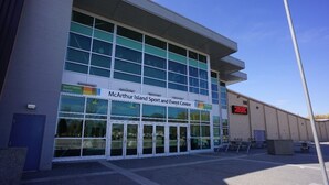 A modern building with large glass windows and a sign reading "McArthur Island Sport and Event Centre." - Feel at home in This 2 Bedroom Basement Suite (Kamloops)