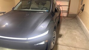 Ein Auto steht in einer Garage mit Betonboden und einer Metalldürre.
