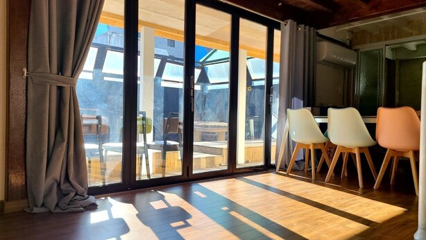 A room with large sliding glass doors, wooden flooring, and a dining area with chairs. - WOO MI GWAN HOTEL (Seoul)
