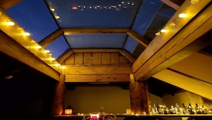 A bar area with a skylight, wooden beams, and string lights. - WOO MI GWAN HOTEL (Seoul)