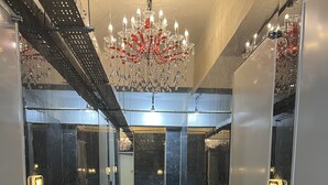 A hallway with mirrored walls, a chandelier, and a door with a light switch. - WOO MI GWAN HOTEL (Seoul)