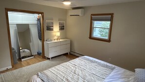 A bedroom with a bed, a dresser, a mirror, and a window. - Lovely cottage with fenced in back yard (Wausau)