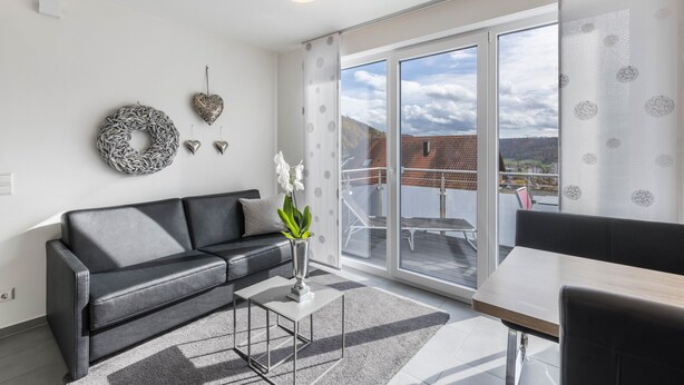 Een moderne woonkamer met een bank, salontafel en decoratieve objecten.
