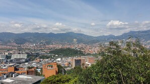 Un paysage urbain composé d’un mélange d’immeubles de grande hauteur et de bâtiments plus petits, le tout entouré de montagnes.