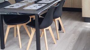 Une table à manger avec des chaises noires et un plancher en bois.