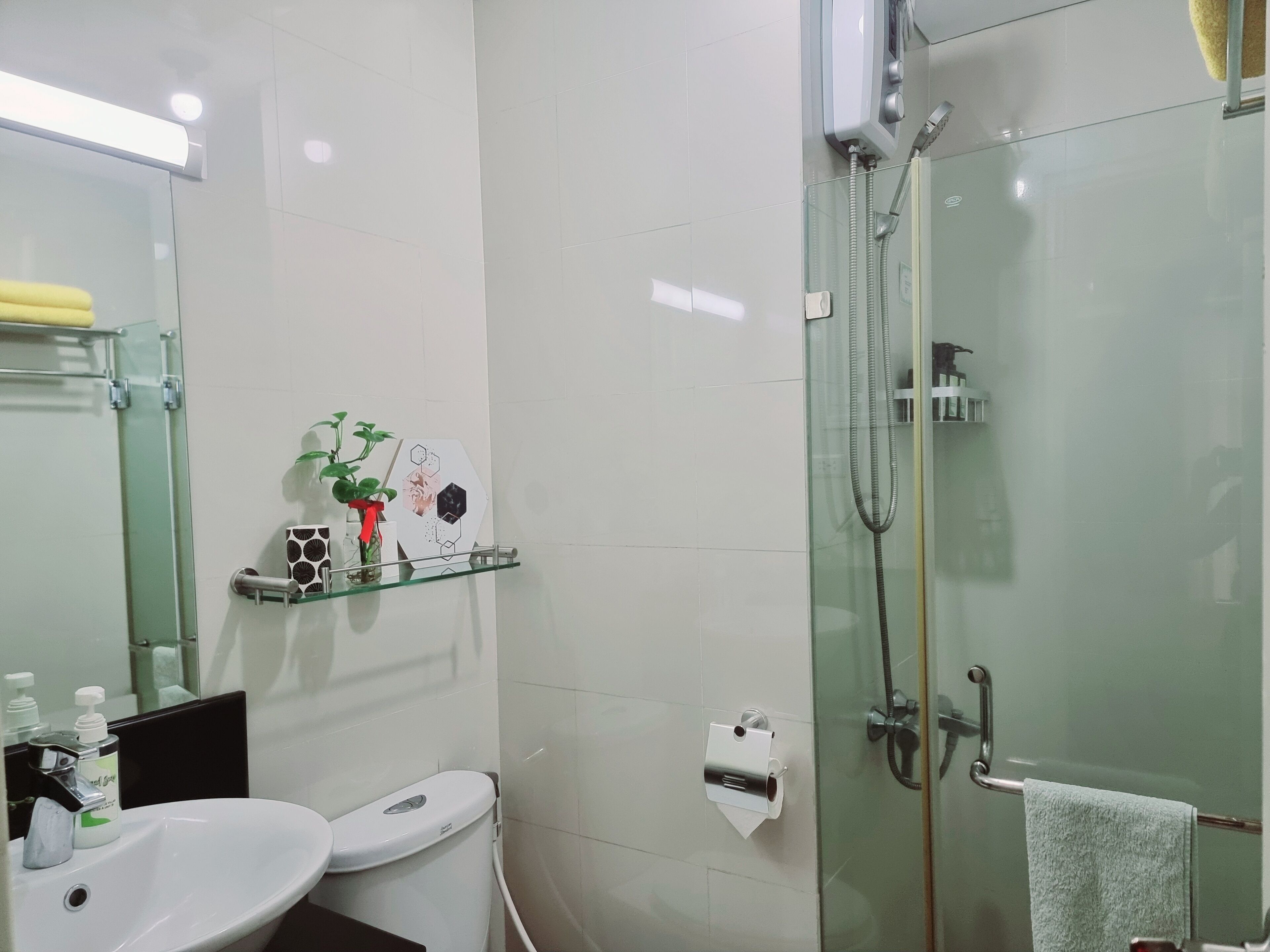 Un bagno moderno con box doccia in vetro, un water e un lavandino con articoli da toilette.