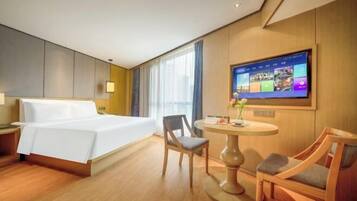 Una habitación de hotel con una cama, un escritorio, una silla y un televisor mostrando un menú.