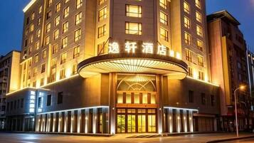 A hotel with a prominent entrance, multiple floors, and a well-lit facade.